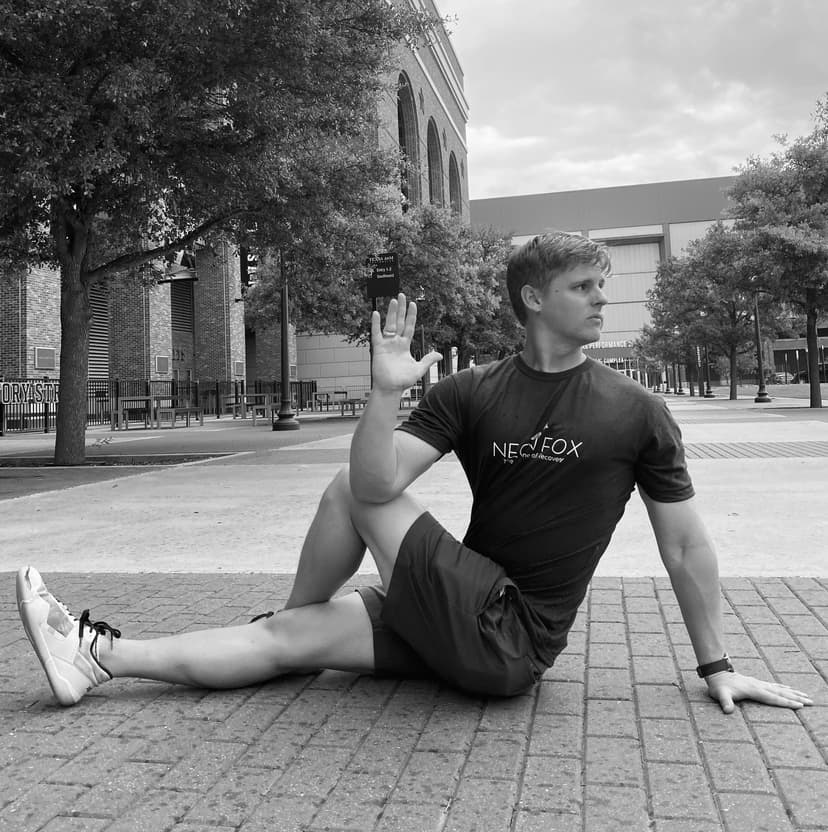 Jeff Whitehead in a seated spinal twist at Kyle Field plaza, Texas A&M